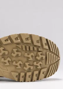Close-up of tactical boot rubber sole featuring deep anti-slip grooves and traction