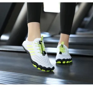 Breathable white barefoot water shoes with neon green accents on a treadmill gym setting