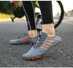 Close-up of grey barefoot water shoes with orange accents and anti-slip rubber sole