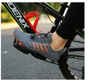 Action shot of grey quick-dry water shoes with orange accents on a cycling pedal