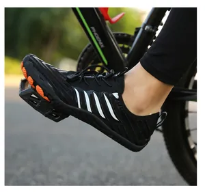 Close-up of black outdoor sports shoe with orange non-slip sole on bicycle pedal