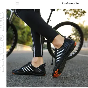 Detail of black and white quick-dry water shoes with orange non-slip grip soles
