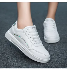 Detailed side view of white platform sneakers with colorful metallic stripes on asphalt