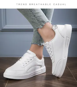 Close-up of white platform sneakers featuring silver side accents and laser heel detail