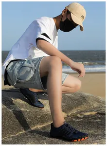 Détail de chaussures aquatiques bleu foncé avec semelle orange antidérapante sur plage