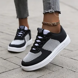 Close-up of black and white fly-knit mesh sneaker with a thick non-slip rubber sole