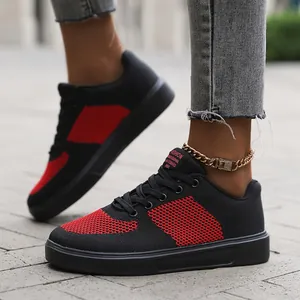 Detail of black and red knitted mesh upper with embroidered lettering on the casual sneaker