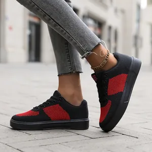 Detailed side view of breathable black and red knit sneakers with durable rubber soles