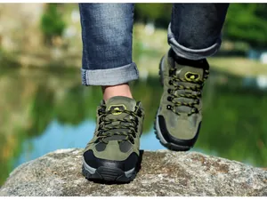 Nahaufnahme von Wildleder-Wanderschuhen mit Gummisohle, die auf einen Felsen treten