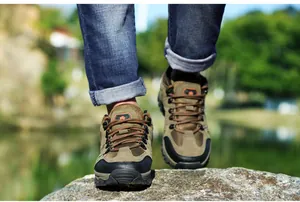 Detail eines Wildleder-Wanderschuhs mit robuster Sohle und orangefarbenen Schnürsenkeln