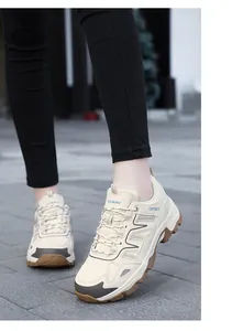 Dettaglio scarpe da trekking beige con mesh traspirante e scritte sport sul sentiero