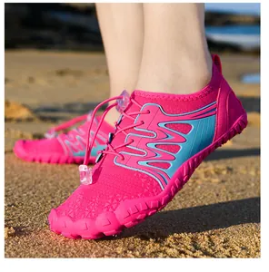 Outdoor barefoot water shoes in pink on sandy beach with elastic laces and rubber sole