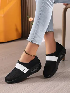 Detail von schwarzen Mesh-Sneakern mit atmungsaktiven Löchern und weißem Fashion-Gummiband