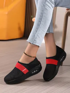 Detail von atmungsaktiven schwarzen Mesh-Sneakern mit rotem Fashion-Band und Luftkissen