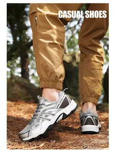 Outdoor view of silver hiking shoes with mesh panels and non-slip thick soles on a forest path
