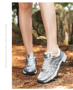 Outdoor shot of stylish silver trekking shoes with mesh details and blue accents