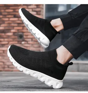 Dettaglio di sneakers in maglia traspirante con suola bianca antiscivolo su sfondo mattoni