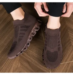 Dettaglio delle sneakers a calzino marroni con suola spessa su pavimento in legno