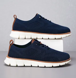 Detailansicht aus dunkelblauem Strickgewebe mit braunen Lederakzenten am leichten Sneaker