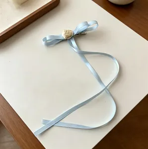Elegant light blue ribbon bow hair clip with a cream rose and long flowing streamers
