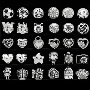 Macro shot of 30 assorted DIY charms featuring animal and heart motifs on a velvet tray
