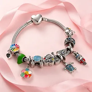 Detail of a gold titanium steel charm bracelet featuring various DIY alphabet pendants