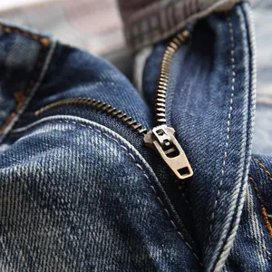 Close-up of vintage dark blue denim shorts featuring a metal zipper and classic yellow stitching