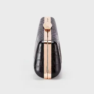 Detail of black faux crocodile leather dinner clutch with rose gold metal frame