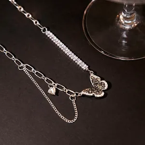 Macro detail of butterfly pendant necklace with shimmering zircons and layered chains
