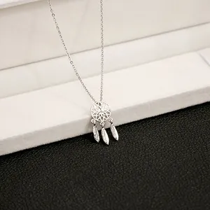 Close-up of dreamcatcher necklace pendant with carved feathers on black leather