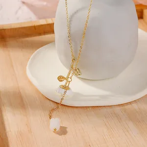 Detail of gold snake chain necklace featuring a white flower pendant and petal accents