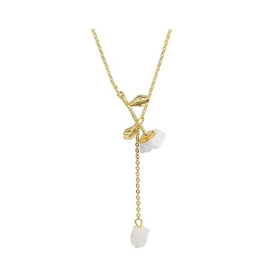 Detail of gold snake chain with elegant white rose pendant and drooping gold leaf elements