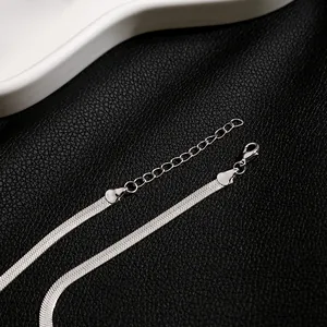 Detailed macro view of silver flat snake chain necklace with lobster clasp and extension