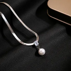 Detail shot of silver snake chain necklace featuring rectangle zircon and white pearl