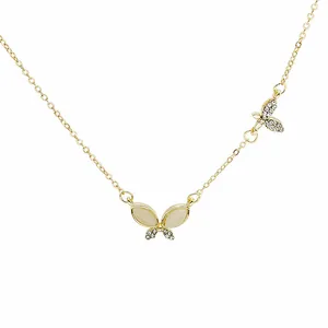 Detail of gold double butterfly necklace with cat-eye stones and pavé crystals