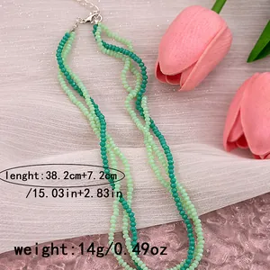 Detail view of multilayer green beaded necklace with lobster clasp and extension chain