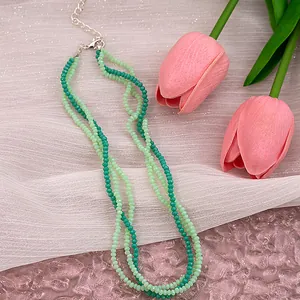Macro view of multi-layer green pearl necklace with silver lobster clasp and extension chain
