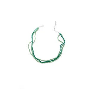 Detail of three-layer green beaded necklace with silver lobster clasp and extension chain