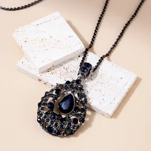 Macro shot of retro teardrop pendant featuring blue rhinestones and hollow metalwork