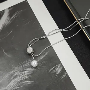 Detailed view of silver snake chain featuring opal slide bead and elegant white pearl pendant