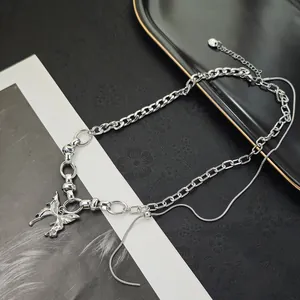 Detail of layered silver butterfly pendant necklace with snake chain and chunky cuban links