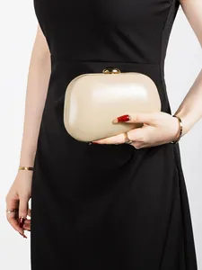 Detail of elegant champagne gold hard shell evening clutch with metallic push-lock closure