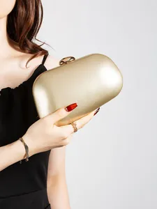 Detailed view of the metallic gold evening clutch bag with elegant clasp and hard shell