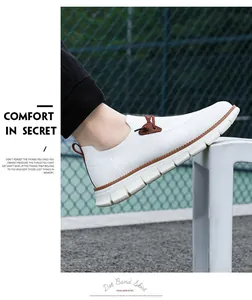Detail of white mesh slip-on shoes featuring brown laces and a thick cushioned sole
