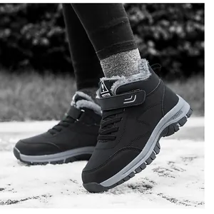 Close-up of waterproof black snow boots with thick grey fleece lining on snowy ground