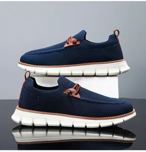 Detail of navy blue knit mesh loafers with white shock-absorbing soles and brown accents