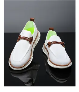 Detail of white mesh loafers featuring brown leather accents and green interior lining