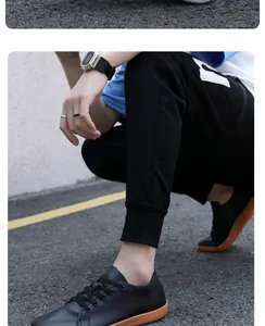 Nahaufnahme minimalistischer schwarzer Sneaker mit brauner Gummisohle und Jogginghose