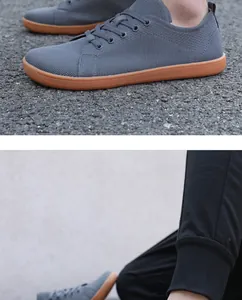 Detailed view of grey breathable mesh barefoot running shoes with durable brown rubber soles