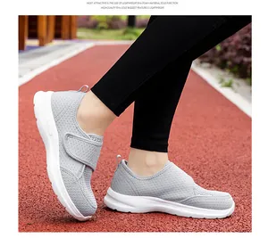 Detail of lightweight gray mesh walking shoes with adjustable strap on a running track